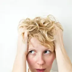 Kobieta z blond włosami, trzymająca się za głowę, z wyrazem zamyślenia. Może to być symbol walki z cyklotymią.
