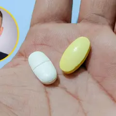 Lekarz z uśmiechem prezentuje dwie tabletki, sugerując rozwiązanie problemu nerwicy luki w pamięci.