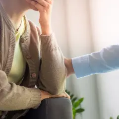 Osoba zmagająca się z depresją paranoidalną otrzymuje wsparcie. Dłoń na ramieniu symbolizuje nadzieję i pomoc.