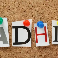 Litery "ADHD" przypięte do korkowej tablicy. Czy ADHD jest dziedziczne? To pytanie nurtuje wielu.
