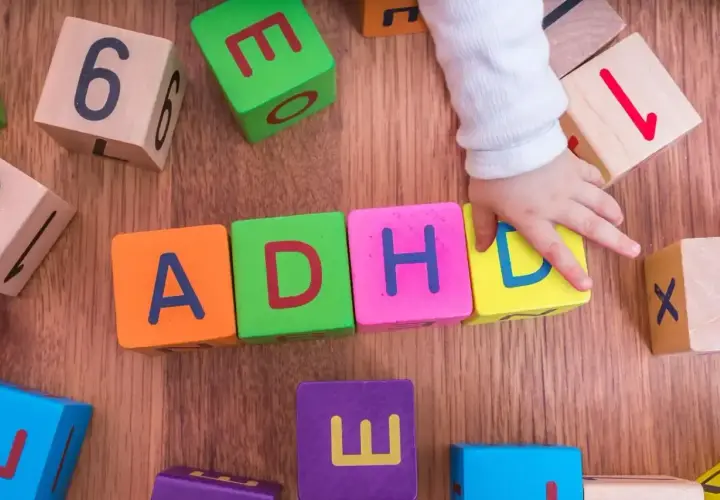 Dziecko układa klocki z literami ADHD. To pokazuje, że spektrum co to jest, może być złożone.