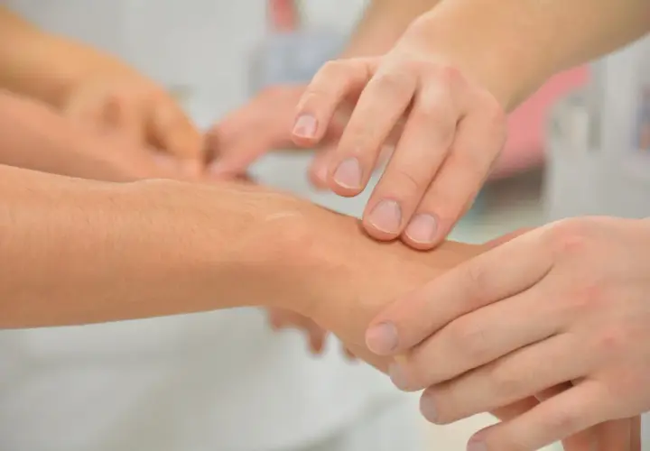 Dłonie badają nadgarstek, szukając oznak wewnętrznego drżenia organizmu.